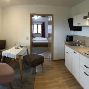 Küchenzeile mit Esstisch und Durchgang zu einem Schlafzimmer - Ferienwohnung (#16)