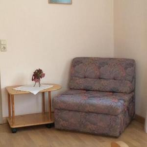 Sessel in einem Wohnbereich mit kleinem Beistelltisch und Holzfußboden - Ferienwohnung (#16)