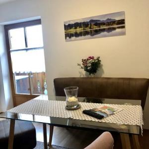 Essbereich mit Bank und Stühlen, dekoriert mit Tischdecke und Blumen - Ferienwohnung (#16)