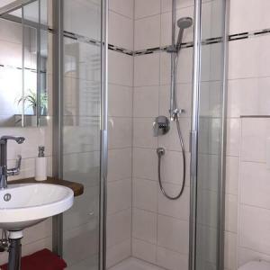 Duschbereich mit Glaswand und weiß gefliesten Wänden - Ferienwohnung (#16)
