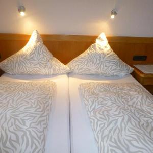 Zwei Einzelbetten mit gemusterten weißen Bettbezügen und Nachttischlampen - Ferienwohnung (#16)