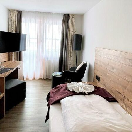 Einzelzimmer (#2) mit gemütlichen Bett und Holzverkleidung an der Wand und Holzeinrichtung