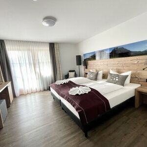 Doppelzimmer mit Doppelbett im Alpenstyle mit Balkon